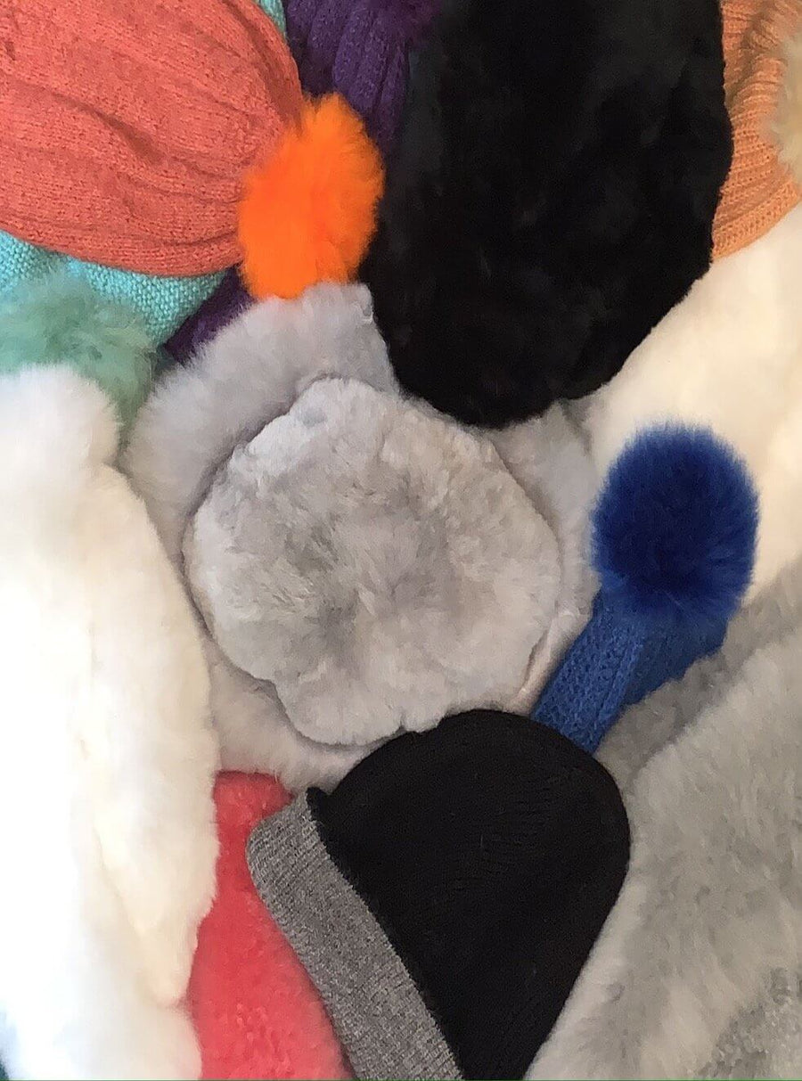 pile of different fur and knit beanies and winter hats