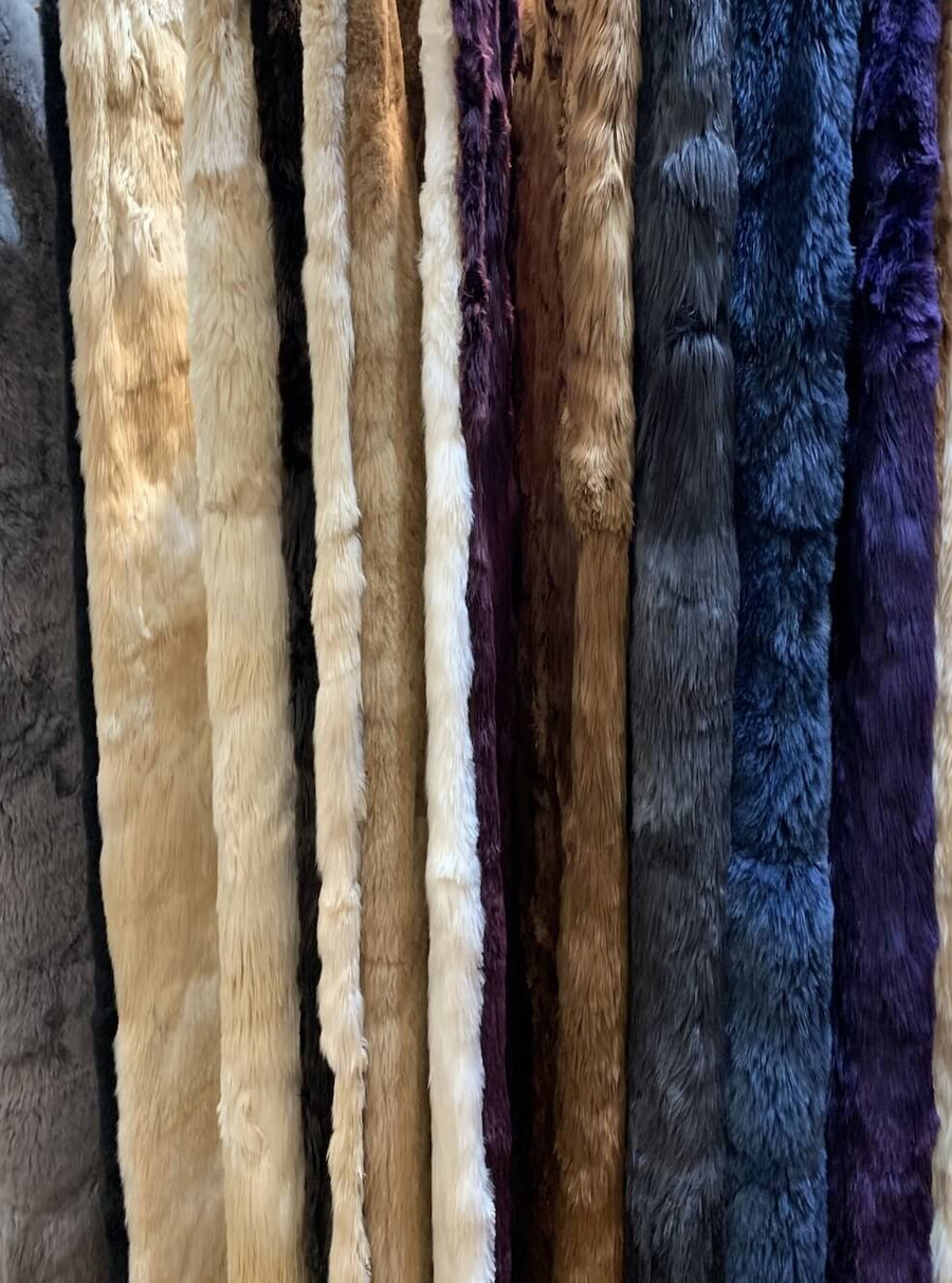 pile of different colored alpaca fur rugs
